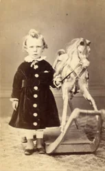 Niña de pie junto a un caballo de balancín, 1870s
